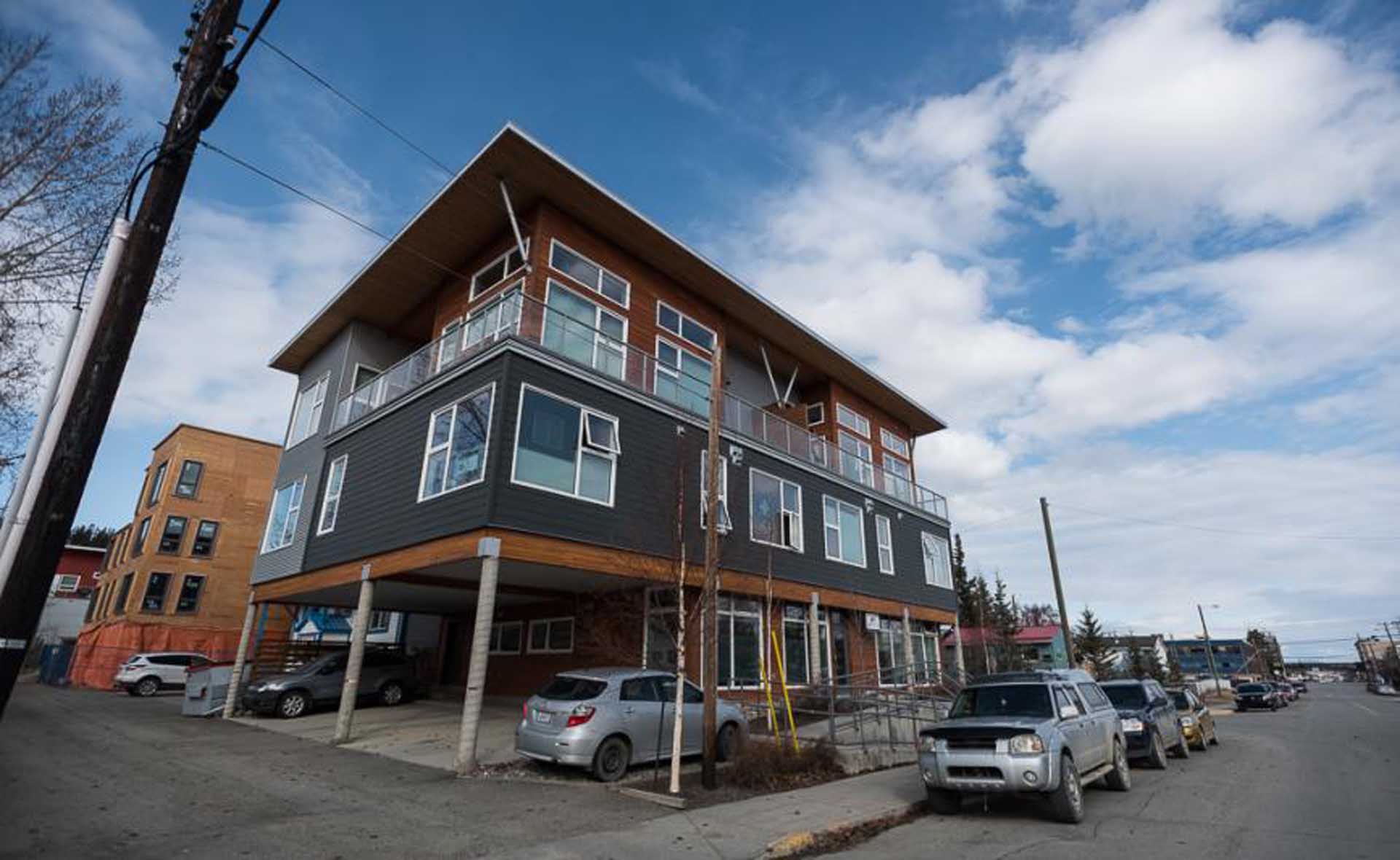 Three story building with parking spaces on the ground level